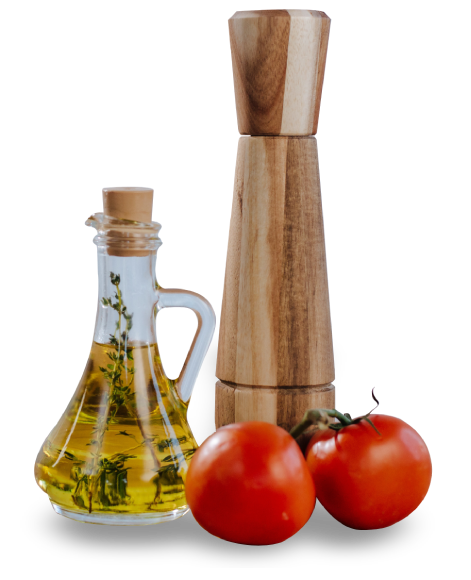 A bottle of oil and two tomatoes next to an olive oil dispenser.